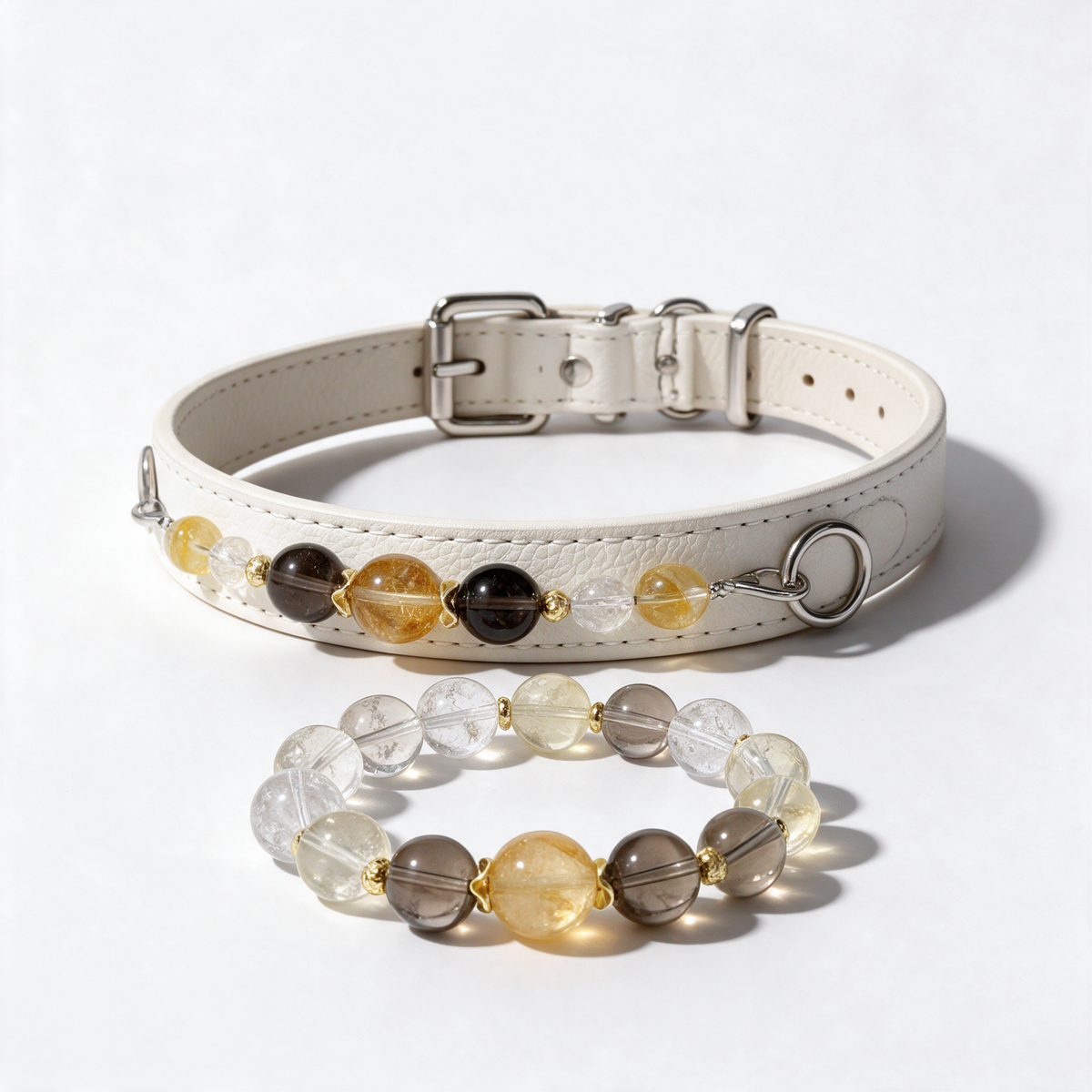 Champagne Light matching set: white stitched dog collar with golden, smoky-brown and clear beads beside its matching owner bracelet on white.