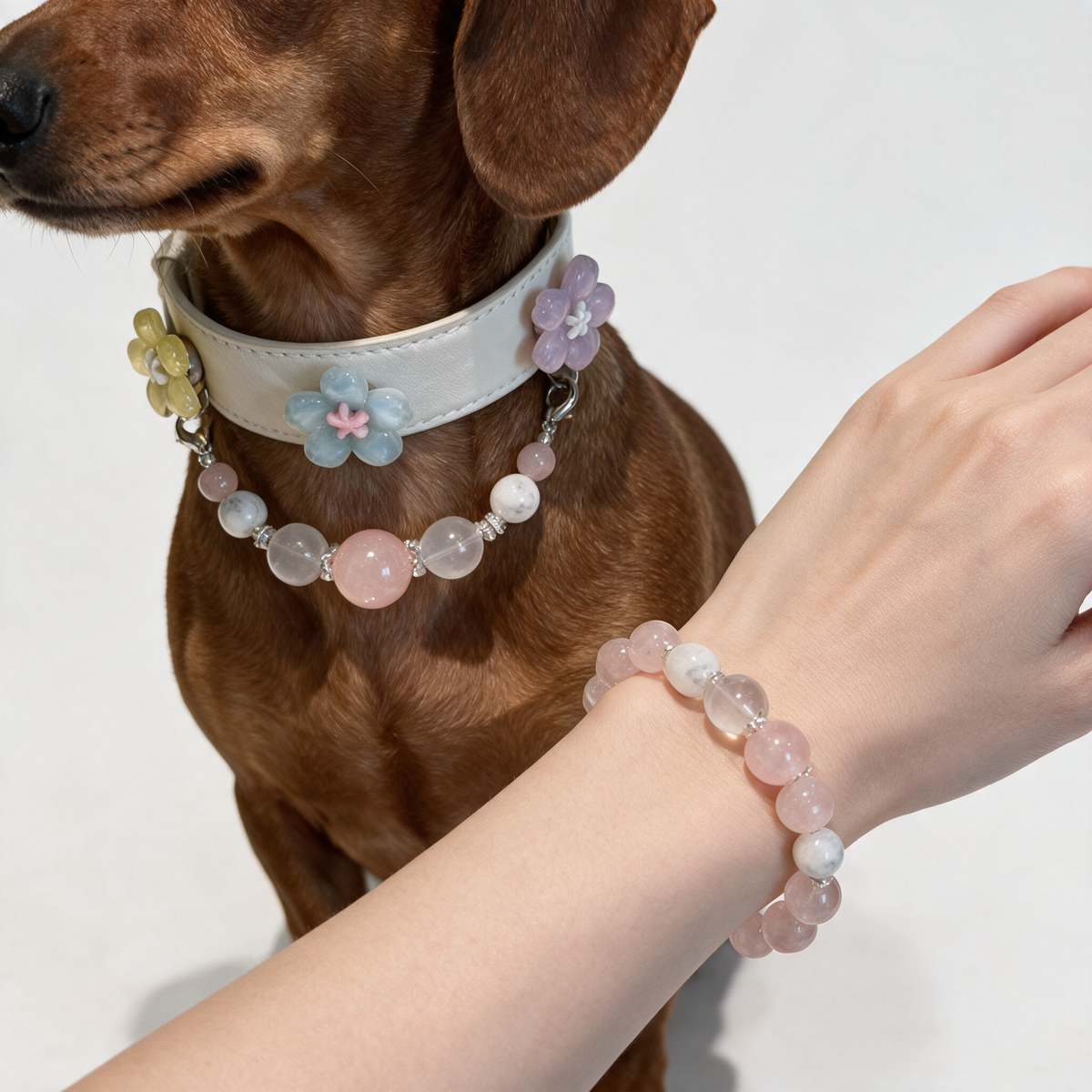 Close view of the Blush Companion floral collar and matching pink bracelet, showing the white stitched band, bead textures and flower accents.