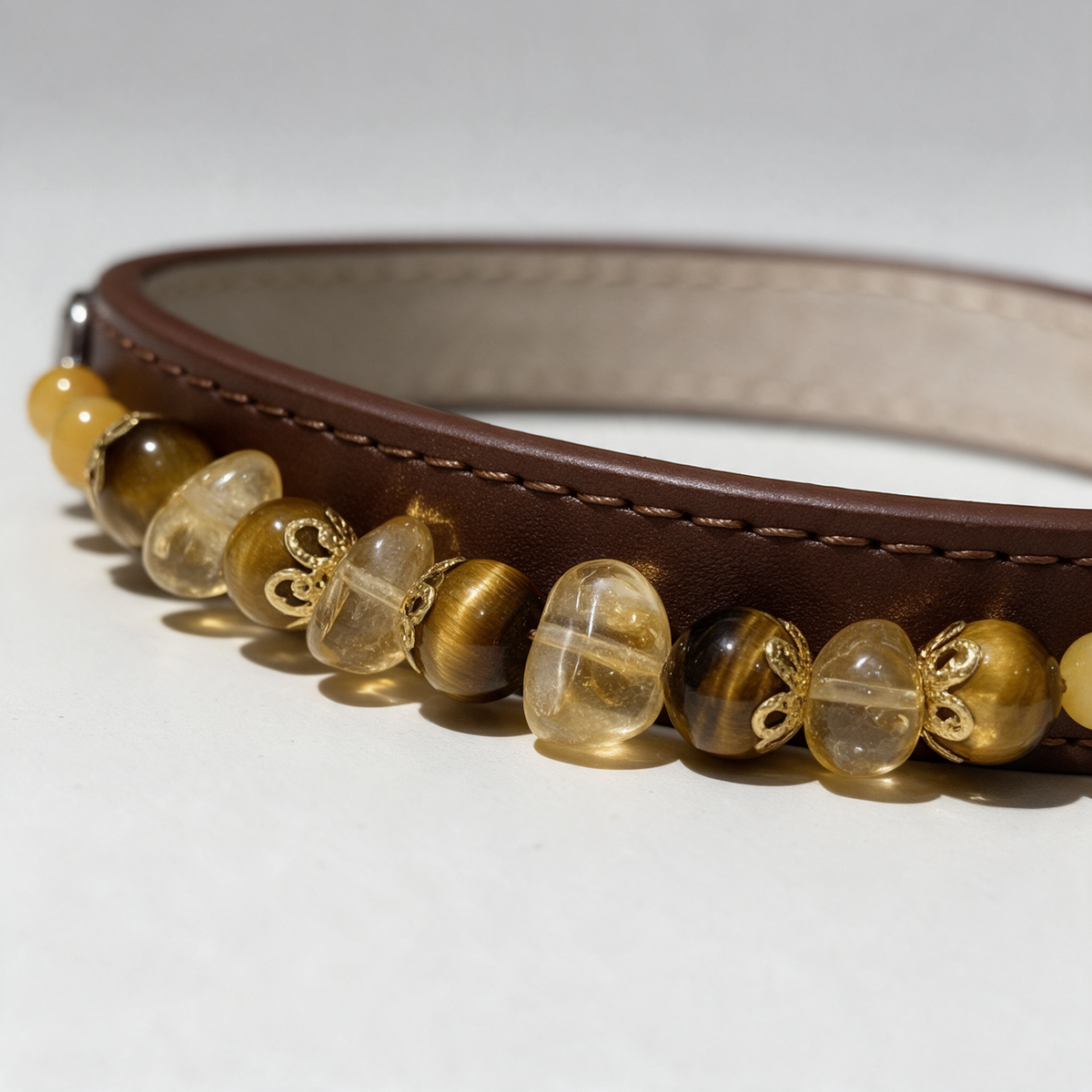Close view of the Tiger Gleam collar, showing tiger-eye bands, pale-yellow irregular beads and gold-tone fittings.