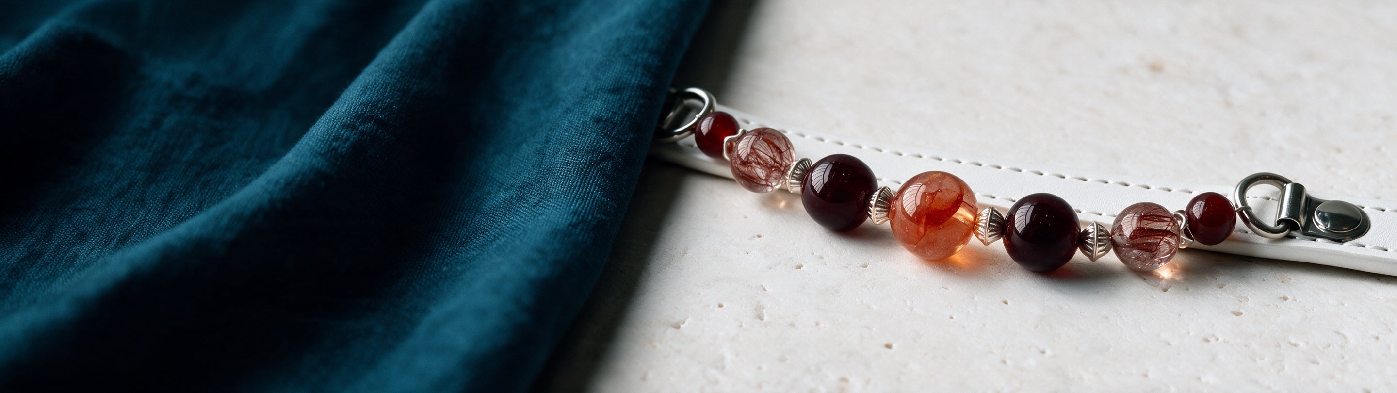 Ember Bond's smooth beads and white strap, in close detail